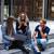 A group of young people sitting on the steps of a building.
